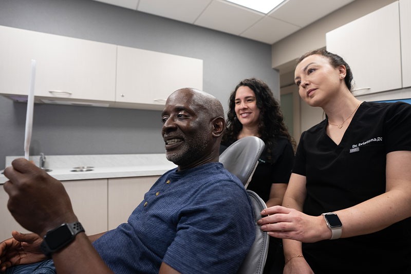 patient looking into the mirror while two doctors look upon